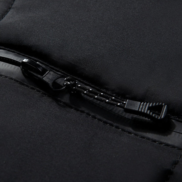 Nahaufnahme eines schwarzen Reißverschlusses auf einer Jacke, hochwertiges Material, modisches Design, funktionale Outdoor-Bekleidung.