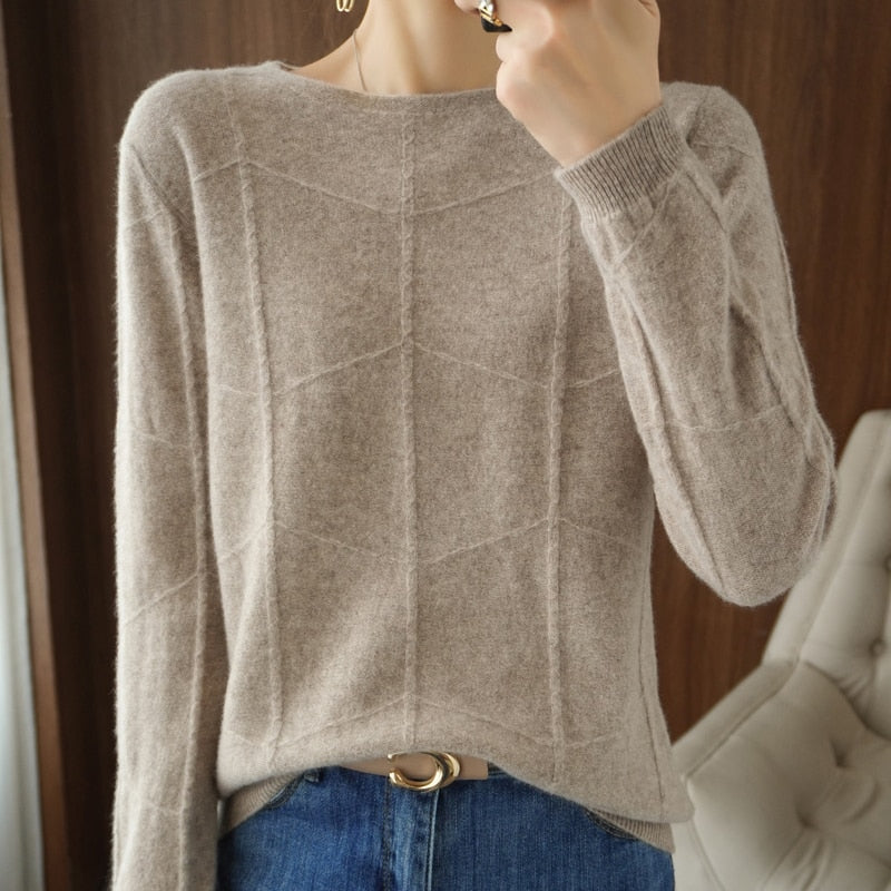 Damenpullover aus beigem Kaschmir mit geometrischem Muster, kombiniert mit blauer Jeans. Elegante Herbstmode, gemütlich und stilvoll.