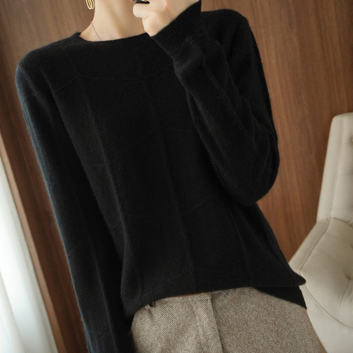 Damen Pullover aus schwarzem Strick, elegant und schlicht, kombiniert mit grauer Hose. Perfekt für Herbstmode und stilvolle Freizeitoutfits.