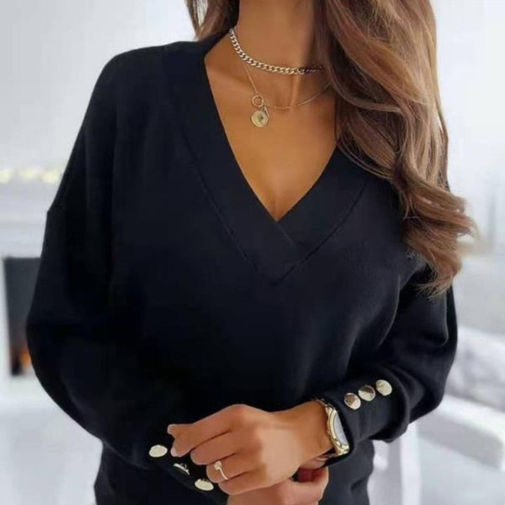Frau in schwarzem V-Ausschnitt-Pullover mit Knöpfen, trägt goldene Halskette und Armbanduhr. Elegante Damenmode, stilvolles Outfit.