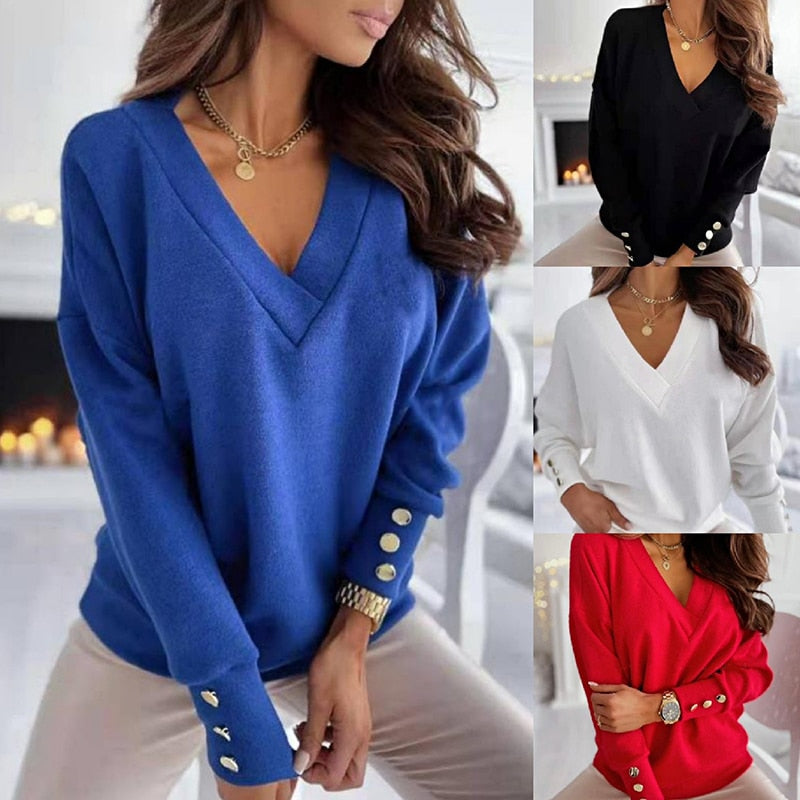Frau trägt blauen Pullover mit V-Ausschnitt und Knöpfen an den Ärmeln. Weitere Farben: Schwarz, Weiß, Rot. Modetrend Damenmode Herbst/Winter.