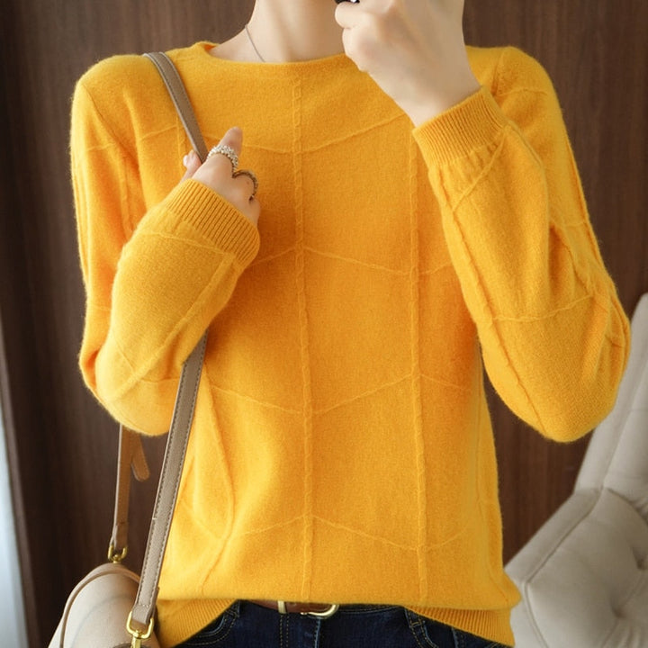 Person in gelbem Pullover mit geometrischem Muster, hält eine beige Handtasche. Modetrend, Herbstmode, Damenbekleidung, stilvoller Look.