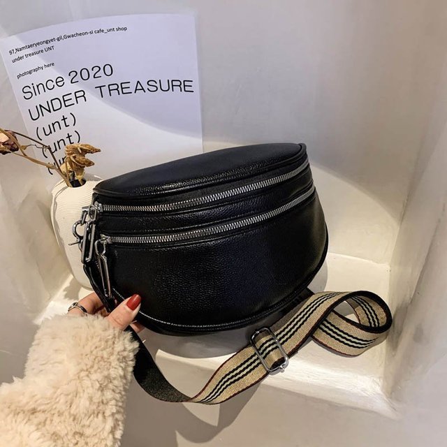 Schwarze Leder-Gürteltasche mit gestreiftem Riemen, präsentiert auf weißem Hintergrund. Modetrend 2023, stilvolles Accessoire, urbaner Look.