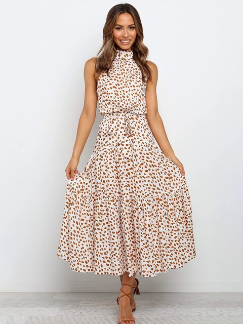 Frau in weißem, ärmellosem Maxikleid mit braunem Leopardenmuster, lächelnd, vor weißem Hintergrund. Modetrend, Sommerkleid, eleganter Look.