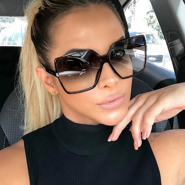 Frau mit großen, eckigen Sonnenbrillen und blondem Pferdeschwanz im Auto. Modische Accessoires, stilvoller Look, Sommermode.