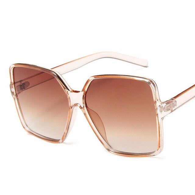 Große, eckige Sonnenbrille mit transparentem Rahmen und braunem Farbverlauf. Modische Damenaccessoires, UV-Schutz, trendige Brillenmode.