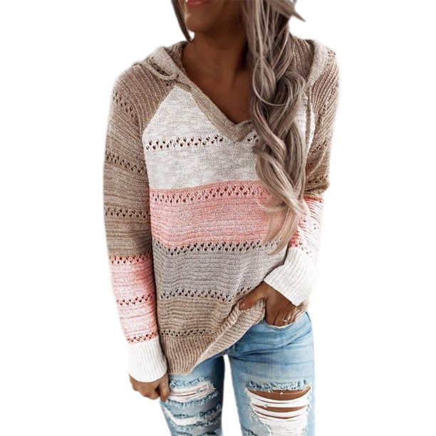Frau in gestreiftem Strickpullover mit Kapuze, beige-rosa-weiß, kombiniert mit zerrissenen Jeans. Modetrend, lässiger Herbstlook.
