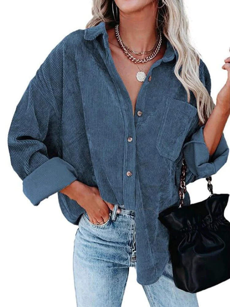 Frau in blauer Cordbluse, lässig geknöpft, kombiniert mit Jeans und schwarzer Tasche. Modetrend, Freizeitlook, Damenmode.