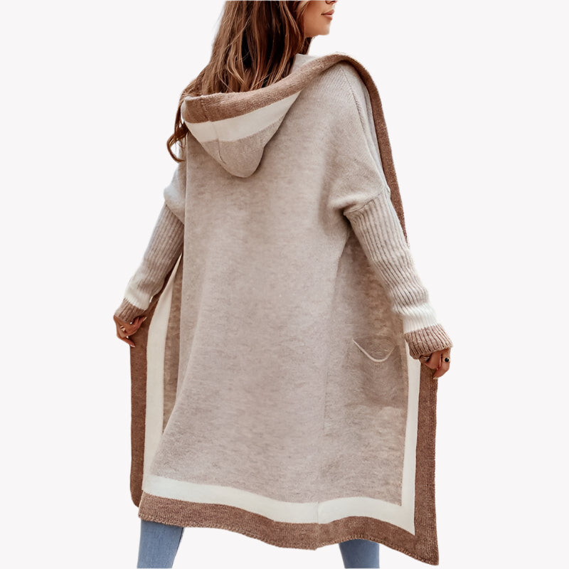 Frau in beigem Strickmantel mit Kapuze, lässig vor einem weißen Hintergrund. Herbstmode-Trend, gemütlicher Look, stilvolle Frauenkleidung, Outdoor-Mode.