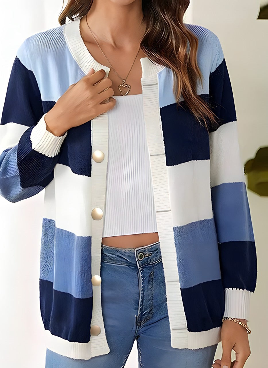 Frau trägt gestreifte Strickjacke in Blau- und Weißtönen, kombiniert mit weißem Top und blauer Jeans. Modetrend, Damenmode, Freizeitlook.
