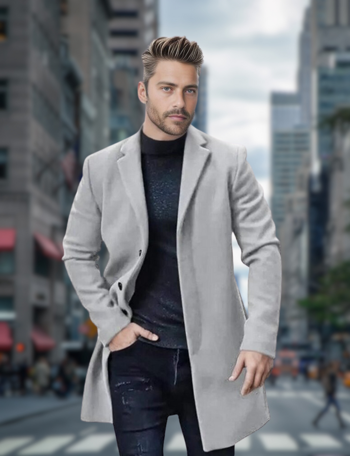 Mann in grauem Mantel und schwarzem Pullover auf belebter Stadtstraße, moderne Mode, urbane Kulisse, stilvoller Look, Herbstmode.