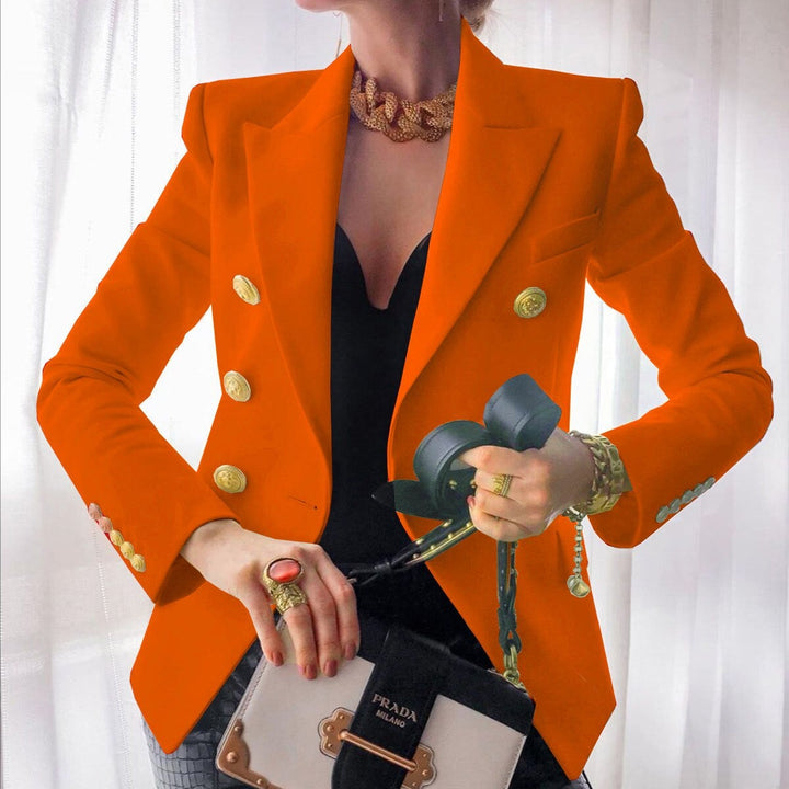 Frau in orangefarbenem Blazer mit goldenen Knöpfen, hält Prada-Tasche und Kopfhörer. Elegante Mode, Luxusaccessoires, stilvolles Outfit.