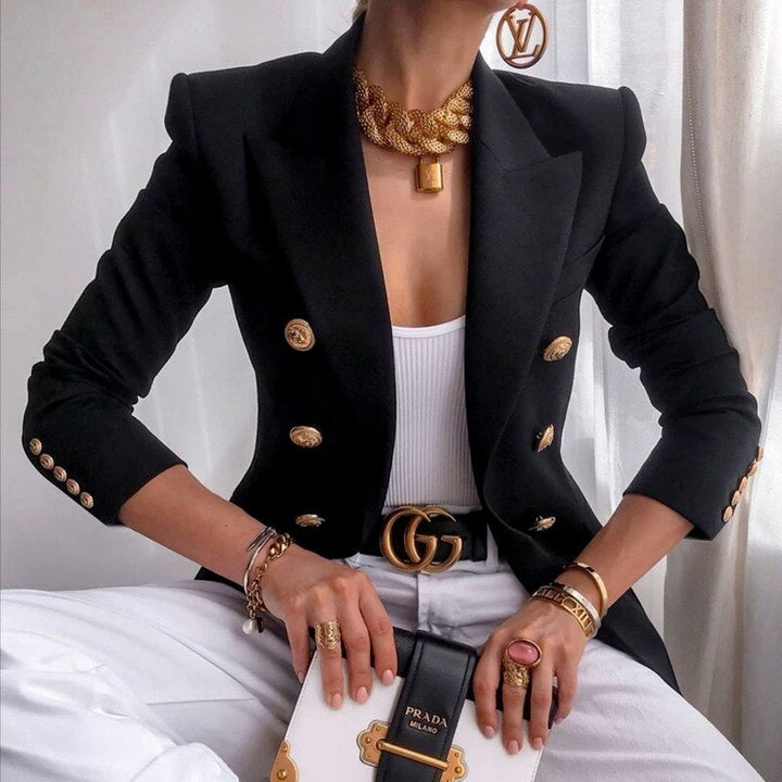 Elegante Frau in schwarzem Blazer mit goldenen Knöpfen, weißem Top, goldenen Accessoires und Prada-Tasche. Mode, Luxus, Damenbekleidung.