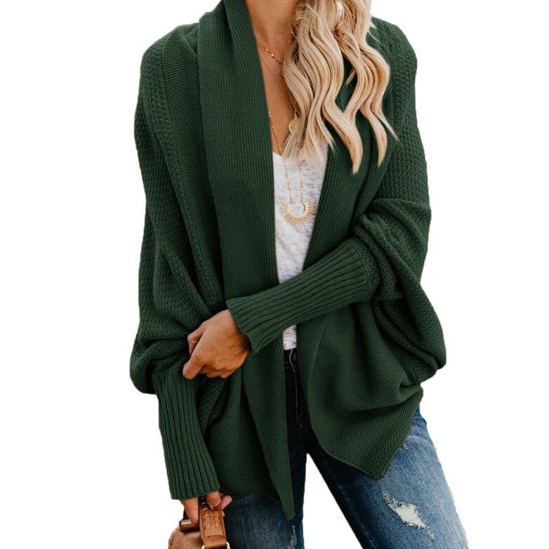 Frau in grünem Strick-Cardigan, weißem T-Shirt und Jeans. Modischer Herbst-Look, lässiger Stil, Damenmode, gemütlicher Strickpullover.