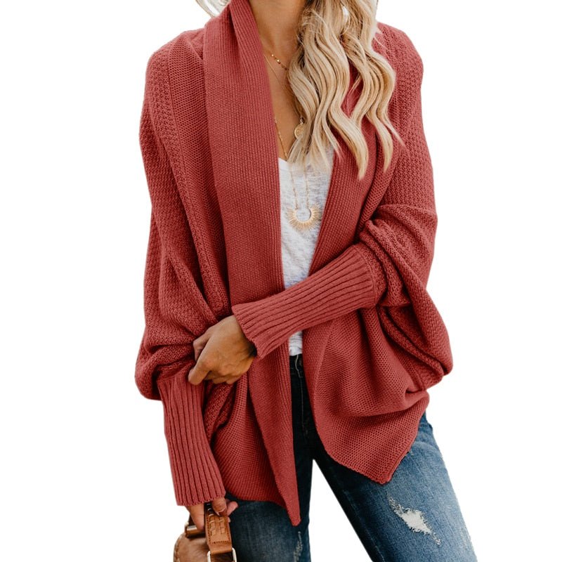 Frau in rotem Strick-Cardigan, weißem T-Shirt und Jeans. Modischer Herbst-Look, lässiger Stil, Damenmode, gemütlicher Strickpullover.