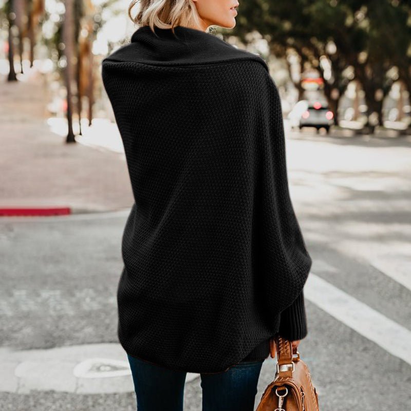 Frau mit schwarzem Strickponcho und brauner Handtasche auf Straße, Herbstmode, stilvoll, lässig, Outdoor, Stadt, Modeaccessoires.
