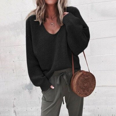 Frau in schwarzem Pullover und olivgrüner Hose mit runder Strohtasche. Modetrend, lässiger Herbstlook, Streetstyle, Damenmode.