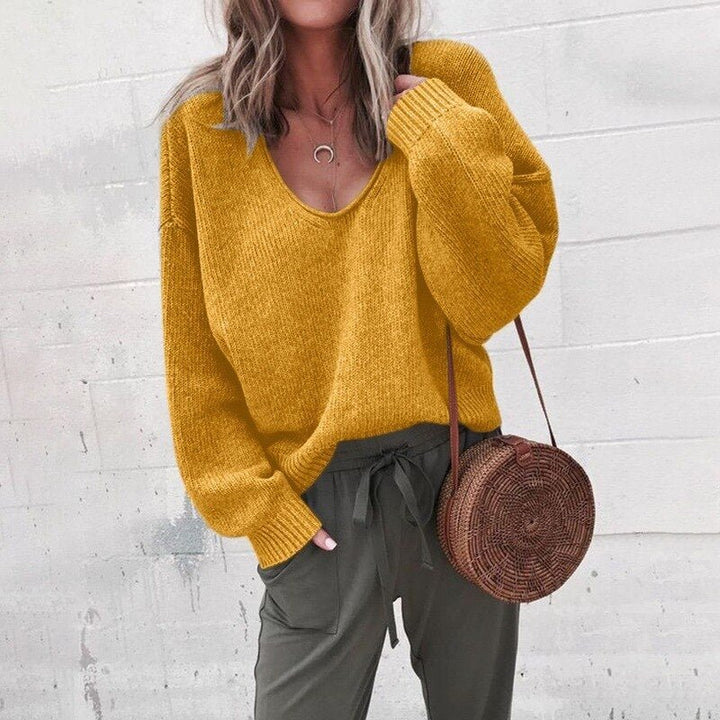 Frau in gelbem Pullover und olivgrüner Hose mit runder Strohtasche. Modetrend Herbst, lässiger Stil, Streetwear, Damenmode.